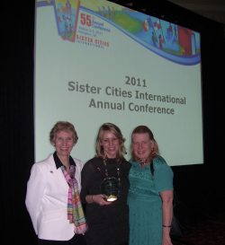 Three Reims committee members in front of presentation